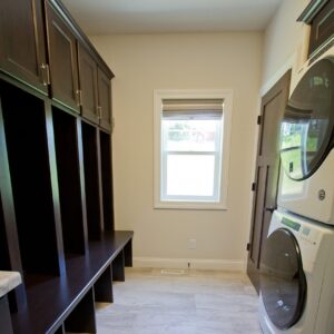A tiled entryway with storage and laundry
