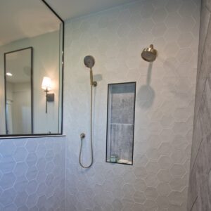 walk in shower with white hexagon wall tile and black hexagon tile floors
