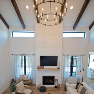 open concept living room with hardwood floors and vaulted ceilings with exposed wood beams.