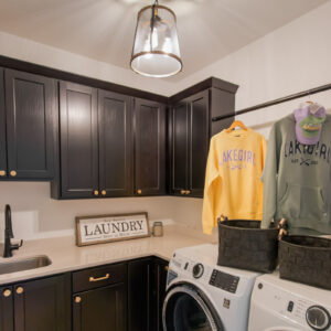 laundry room with herringbone tile pattern and dark wood cabinets