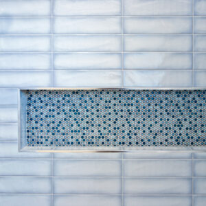 light blue undulated tile with blue penny round mosaic tile