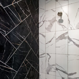 tranquil verdure primary shower design using white marbled wall tile from MSI, eden 12x24 statuary white; black marbled wall tile from daltile, perpetuo 12x24 infinite black; black hexagon mosaic floor tile from daltile in perpetuo infinite black