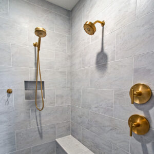 Classic Elegance Design, Custom shower featuring 12x24 fluted tile walls, non-fluted Daltile porcelain tile in Brilliant White, pebble floor, and built-in bench with Schluter system installation.