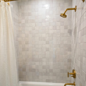 4x4 Ragno Melange Blanco tile used for bathroom walls and floors, featuring an undulating surface and white color variations that adds a sophisticated touch to the space.