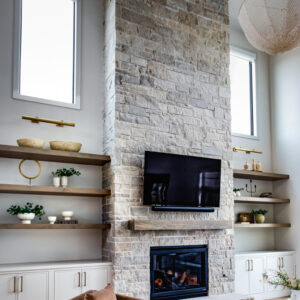 Great room featuring light-colored engineered wood floors, built-in open shelving with a wood top, and white cabinets for sleek media storage