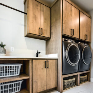 The laundry room features Emser Contessa 12x24 Oro matte porcelain tile, providing a durable and elegant flooring solution that enhances the space with a modern, neutral look.