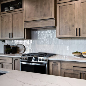 This modern kitchen is enhanced by a fluted tile backsplash, adding texture and elegance to the space, perfectly complementing the clean lines and functional design.